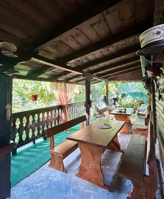 an outdoor patio with a wooden table and benches at Oasis Guest House in Dobrinishte