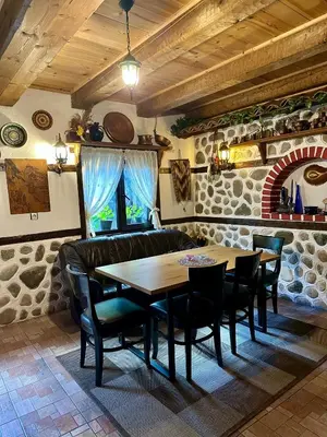 a dining room with a wooden table and chairs at Oasis Guest House in Dobrinishte