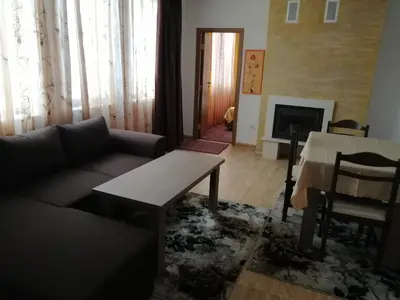 a living room with a couch and a table and a fireplace at GRAND MONASTERY Apartment ``WHITE TALE`` in Pamporovo