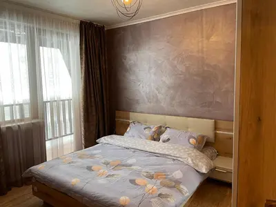 a bedroom with a bed with a painting on the wall at Гранд Манастира Частен Апартамент in Pamporovo