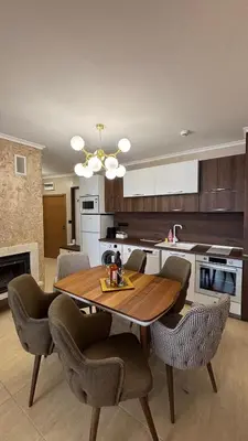 a kitchen with a wooden table and chairs in a room at Гранд Манастира Частен Апартамент in Pamporovo