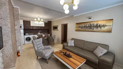 a living room with a couch and a table at Гранд Манастира Частен Апартамент in Pamporovo