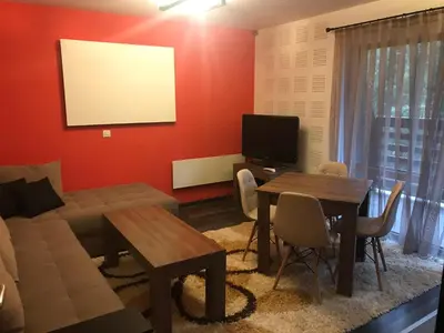 a living room with a couch and a table at Pamporovo Central Apartments in Pamporovo