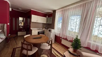a kitchen with a table and chairs in a room at Top of the Mountain Гранд Манастира частни Апартаменти in Pamporovo