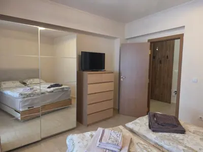 a bedroom with two beds and a television on a dresser at Top of the Mountain Гранд Манастира частни Апартаменти in Pamporovo