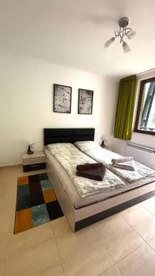 a bedroom with a large bed with green curtains at Top of the Mountain Гранд Манастира частни Апартаменти in Pamporovo
