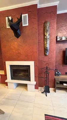 a living room with a fireplace and a mask on the wall at Top of the Mountain Гранд Манастира частни Апартаменти in Pamporovo