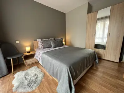 a bedroom with a bed and a table and a chair at MH Apartments in Bansko