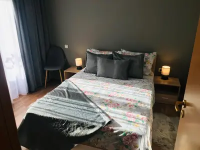 a bedroom with a bed with a comforter and pillows at MH Apartments in Bansko