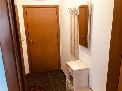 a bathroom with a toilet and a wooden door at MH Apartments in Bansko