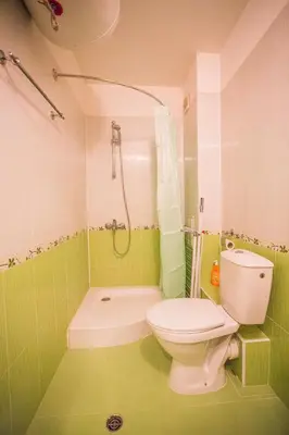 a green bathroom with a toilet and a shower at Cozy Colorful Studio at the foot of the Mountain by Flat Mаnager in Bansko