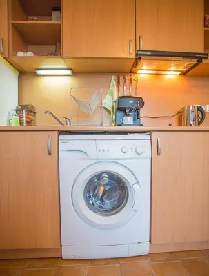 a kitchen with a washing machine in a kitchen at Cozy Colorful Studio at the foot of the Mountain by Flat Mаnager in Bansko