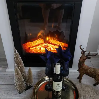 a bottle of wine in front of a fireplace at MAGRI Luxurious Apartment A42 Borovets Gardens in Borovets