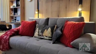 a gray couch with pillows on it in a living room at Pinewood ANG luxurious apartment A32 in Borovets