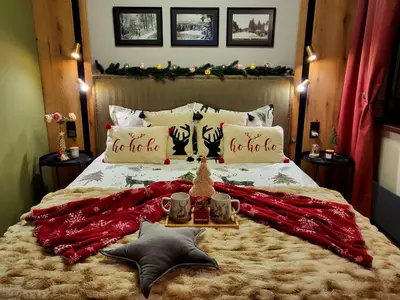 a bed with a red blanket and two mugs on it at Pinewood ANG luxurious apartment A32 in Borovets