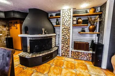 a living room with a fireplace in a room at Луксозен Апартамент Мечи Чал - Апартхотел Манастира 2 in Pamporovo