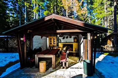 a wooden shelter with a table and a fireplace at Луксозен Апартамент Мечи Чал - Апартхотел Манастира 2 in Pamporovo