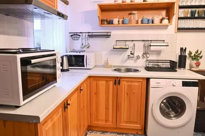 a kitchen with a microwave and a washer and dryer at 4 BDR House Monument of Culture & Architecture by Flat Mаnаger in Bansko