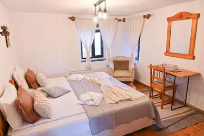 a bedroom with a bed and a table and a chair at 4 BDR House Monument of Culture & Architecture by Flat Mаnаger in Bansko