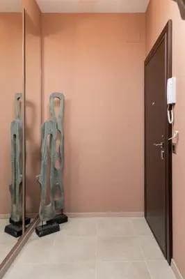 a hallway with a door and sculptures on the wall at ~Angels ~ Two-Bedroom Deluxe Flat in City Centre in Sofia