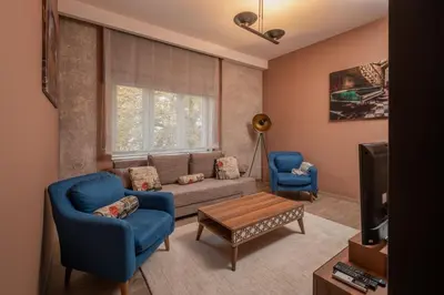 a living room with a couch and two blue chairs at ~Angels ~ Two-Bedroom Deluxe Flat in City Centre in Sofia