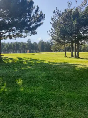 a grassy field with trees in a park at Rustic Spa at Pirin Golf in Razlog