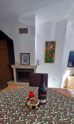 a bottle of wine sitting on top of a bed at BOGI SPA Apartment Pamporovo in Pamporovo