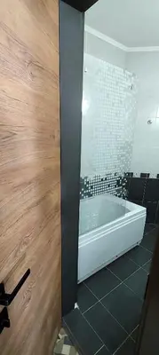 a bathroom with a bath tub with a glass wall at BOGI SPA Apartment Pamporovo in Pamporovo