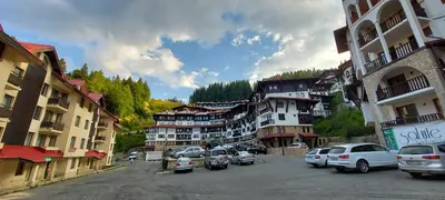 a town with cars parked in a parking lot at BOGI SPA Apartment Pamporovo in Pamporovo