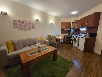 a living room with a couch and a table and a kitchen at Bansko Boutique Apartments - Flora Boutique in Bansko