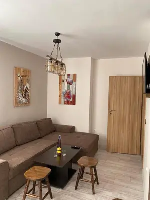 a living room with a couch and a table at Borovets Gardens Ski Apartment in Borovets