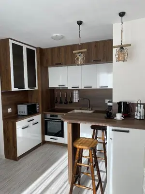 a kitchen with white cabinets and a wooden counter top at Borovets Gardens Ski Apartment in Borovets