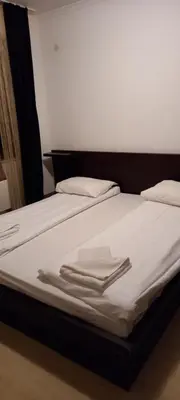 a bed with white sheets and folded towels on it at Ski Place in Pamporovo