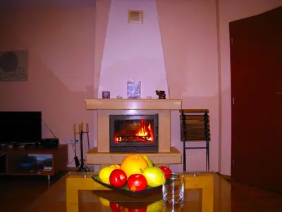 a bowl of fruit on a table in front of a fireplace at Solar nest with fireplace and mountain view - near ski lift and center in Bansko