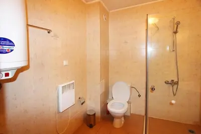 a bathroom with a toilet and a glass shower at Solar nest with fireplace and mountain view - near ski lift and center in Bansko