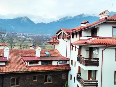 a group of buildings with mountains in the background at Solar nest with fireplace and mountain view - near ski lift and center in Bansko