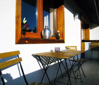 a table in front of a window with a vase on it at Solar nest with fireplace and mountain view - near ski lift and center in Bansko