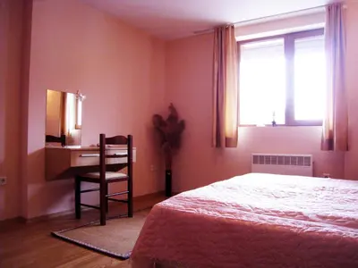 a bedroom with a bed and a desk and a chair at Solar nest with fireplace and mountain view - near ski lift and center in Bansko