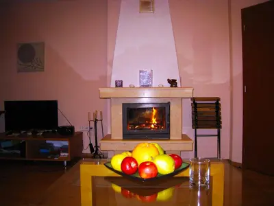 a bowl of fruit on a table in a living room with a fireplace at Solar nest with fireplace and mountain view - near ski lift and center in Bansko