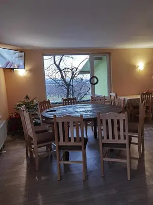 a dining room with a large wooden table and chairs at Винарна-Славовица in Kalugerovo