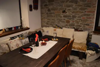 a table in a living room with a couch at Yakusha - Якуша, къща за гости in Shiroka Lŭka