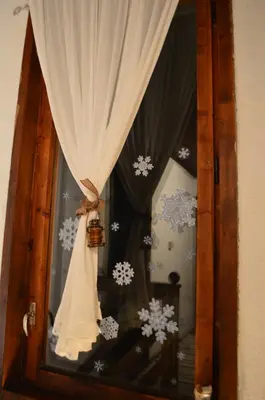 a door with a window with a curtain and snow at Yakusha - Якуша, къща за гости in Shiroka Lŭka