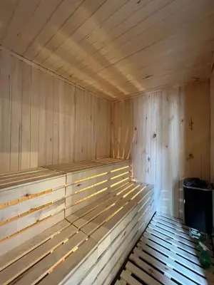 an empty wooden sauna with a trash can in it at Bashtin Dom - Skabrin House in Bansko