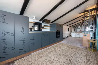 a kitchen with gray cabinets and a rug at Bashtin Dom - Skabrin House in Bansko