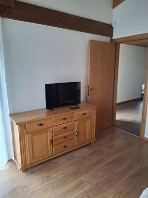 a living room with a tv on a wooden dresser at Pirin Golf Villa in Bansko