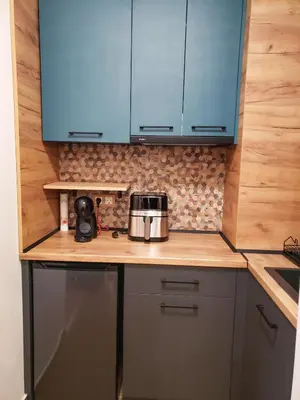 a kitchen with blue cabinets and a toaster on a counter at Borovets Forest view (A56) in Borovets