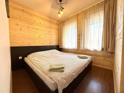 a bedroom with a bed in a wooden wall at Bansko Royal Towers - Studio 815 in Bansko