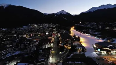 a city lit up at night with mountains in the background at Bansko Royal Towers - Studio 815 in Bansko