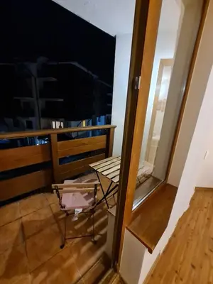 a balcony with a chair and a window at Vesta Boutique Apartment in Bansko