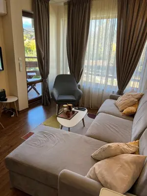 a living room with a couch and a chair at Vesta Boutique Apartment in Bansko